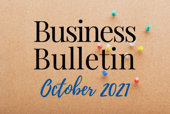 cork board with pins pushed in and words reading business  bulletin october 2021