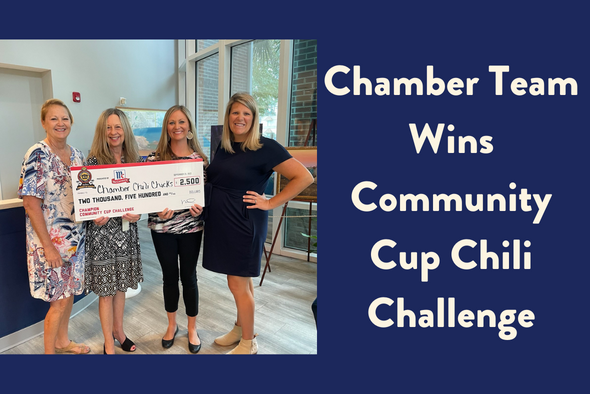 chamber team smiles for camera holding big check for $2,500