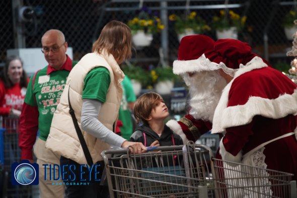 Photo of child shopping with woman and meeting Santa Claus and Mrs. Claus.