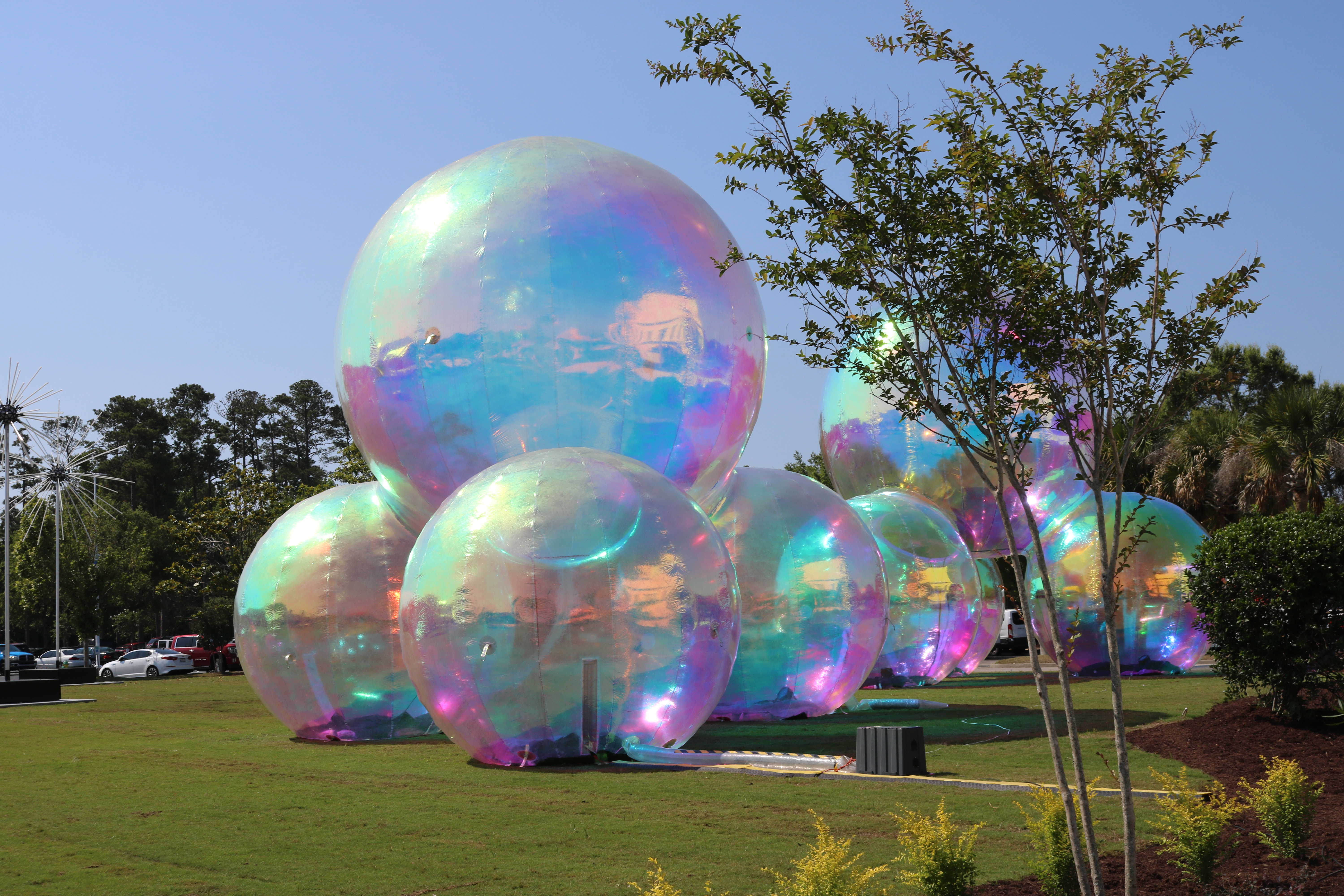 large Iridescent balls are stacked on grass