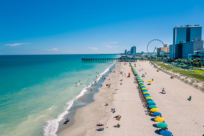 Umbrellas line the sand during a sunny day at Myrtle Beach