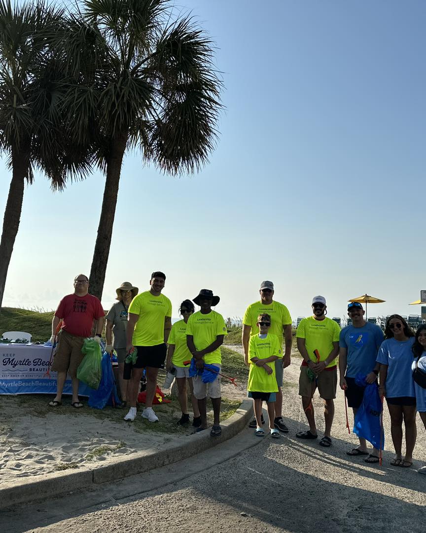 KMBB volunteers stand to smile for a photo at the beach in Myrtle Beach.