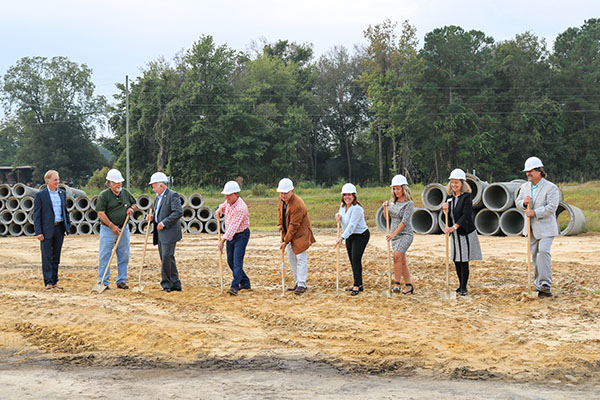 group of people with shovels and hard hats smiling for photo